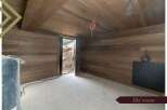 This stunning ski room boasts a modern design with sleek dark wood paneling on the walls and ceiling, creating a warm and inviting atmosphere.