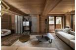 This stunning chalet boasts a spacious living area with floor-to-ceiling windows offering breathtaking mountain views.