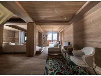 This stunning chalet boasts a spacious open-plan living area with floor-to-ceiling windows offering breathtaking mountain views.