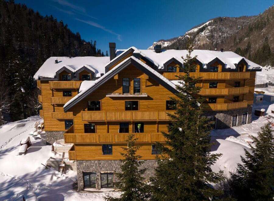 Nestled in a snowy mountainside, this stunning wooden chalet offers breathtaking views and luxurious accommodations.