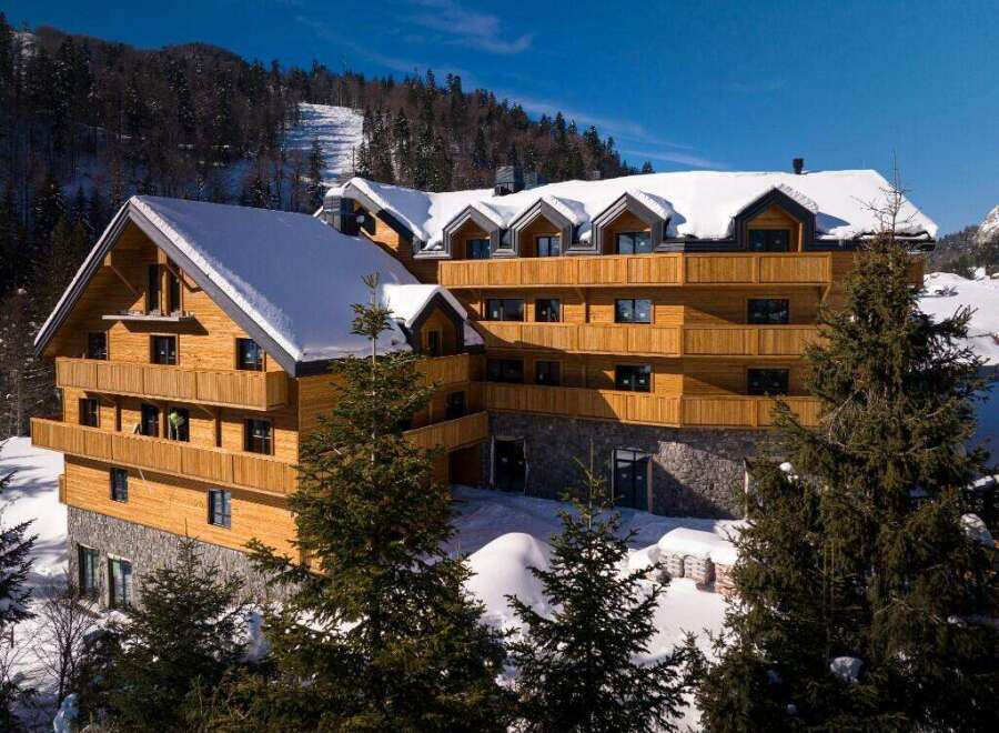 Nestled in a snowy mountainside, this stunning wooden chalet offers breathtaking views and luxurious accommodations.
