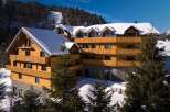 Nestled in a snowy mountainside, this stunning wooden chalet offers breathtaking views and luxurious accommodations.