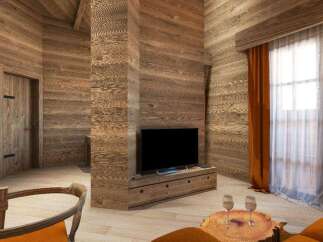 This stunning chalet boasts a cozy living area with a rustic wooden interior, featuring a large flat-screen TV and comfortable seating.