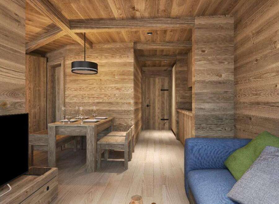 This stunning chalet boasts a spacious open-plan living area with a rustic wooden dining table and comfortable blue sofa.