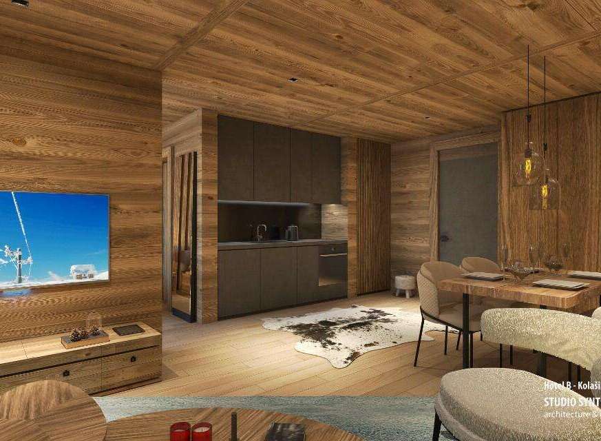 This stunning hotel room boasts a cozy and modern design, featuring a spacious living area with a large TV and a comfortable seating arrangement.