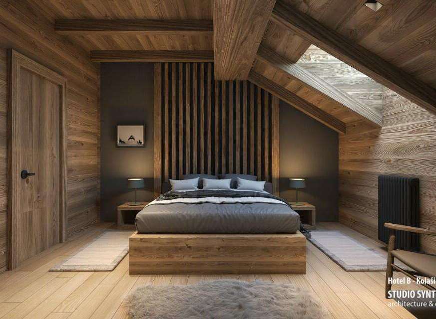 This stunning hotel room boasts a cozy, rustic-chic design with exposed wooden beams, a wood-paneled wall, and a platform bed.