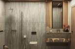 This luxurious bathroom boasts a serene atmosphere with its natural stone wall tiles and wooden accents.