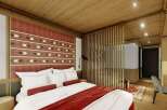 This hotel room features a comfortable king-size bed with plush bedding and a stylish red throw.