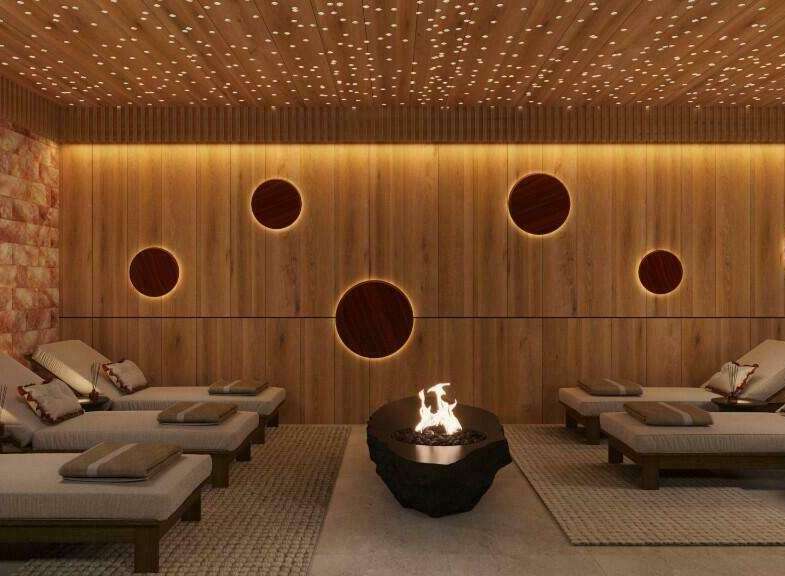 Indulge in ultimate relaxation in this luxurious spa, featuring a stunning Himalayan salt wall, ambient lighting, and comfortable lounge chairs.
