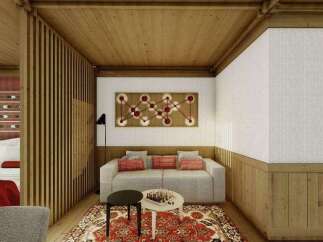 This stunning hotel room boasts a unique blend of modern and traditional design, featuring a cozy sitting area with a comfortable sofa and a stylish rug.