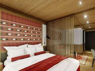 This hotel room features a comfortable king-size bed with plush bedding and a stylish red throw.