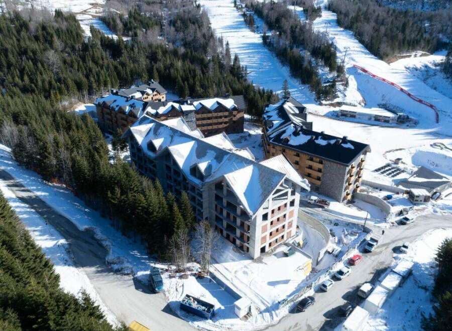 This stunning aerial view showcases a luxurious ski resort nestled in a snow-covered mountainside.