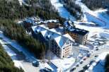 This stunning aerial view showcases a luxurious ski resort nestled in a snow-covered mountainside.