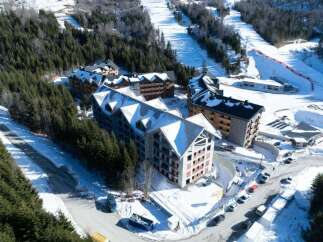 This stunning aerial view showcases a luxurious ski resort nestled in a snow-covered mountainside.