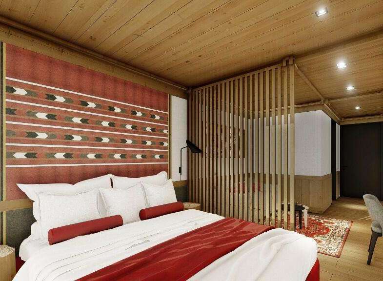 This hotel room features a comfortable king-size bed with plush bedding and a stylish red throw.