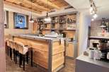This rustic bar boasts a warm and inviting atmosphere with its wooden accents and stylish pendant lighting.