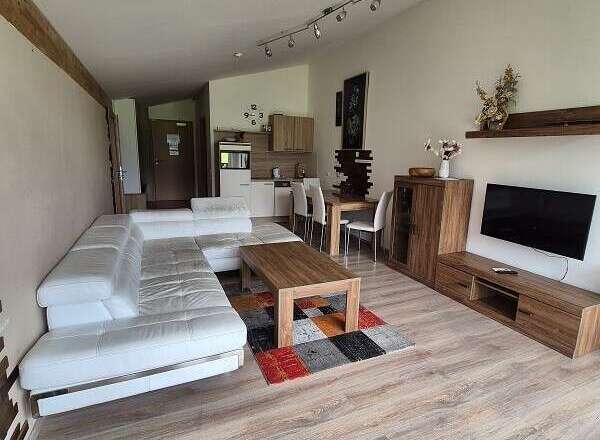 Discover a modern living space with a sleek white sofa and stylish wooden furniture.