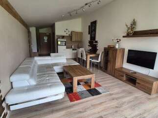 Discover a modern living space with a sleek white sofa and stylish wooden furniture.