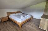 Cozy bedroom with a wooden bed frame and matching nightstand.