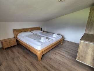 Cozy bedroom with a wooden bed frame and matching nightstand.