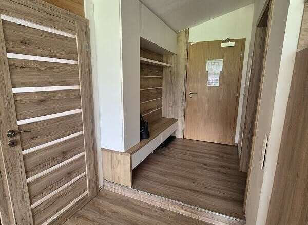 Step into this inviting entryway, featuring stylish wooden doors and flooring that exude warmth.
