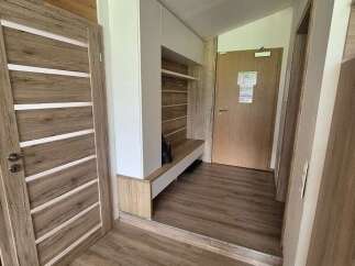 Step into this inviting entryway, featuring stylish wooden doors and flooring that exude warmth.