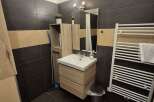 This modern bathroom features sleek dark tile flooring and a stylish vanity with ample storage.