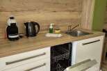 Modern kitchen with sleek white cabinetry and a built-in dishwasher.