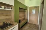 Step into this inviting space, featuring a modern kitchenette with sleek cabinetry and a stainless steel sink.