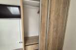 This property boasts a modern design with a stylish wooden wardrobe, offering ample storage space.