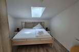 This cozy bedroom features a comfortable bed with fresh linens and a bright skylight.