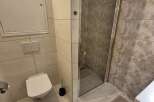 This modern bathroom features a sleek, tiled design with a walk-in shower.