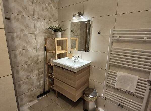 This modern bathroom features a stylish wooden vanity and a sleek, minimalist design.