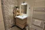 This modern bathroom features a stylish wooden vanity and a sleek, minimalist design.
