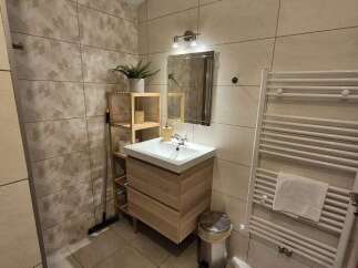 This modern bathroom features a stylish wooden vanity and a sleek, minimalist design.
