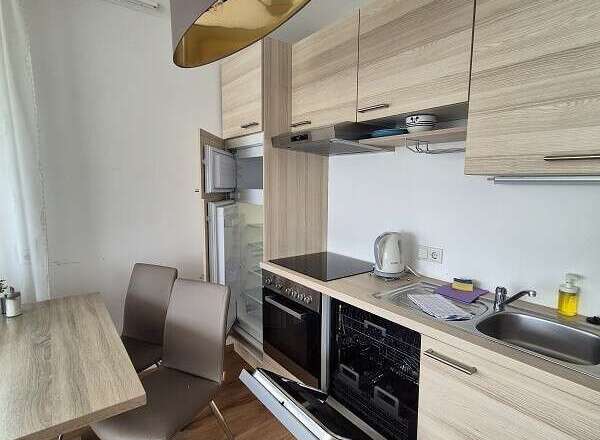 This modern kitchen boasts sleek cabinetry and a functional layout, perfect for preparing meals.