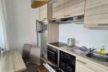 This modern kitchen boasts sleek cabinetry and a functional layout, perfect for preparing meals.