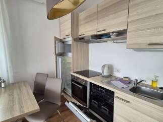 This modern kitchen boasts sleek cabinetry and a functional layout, perfect for preparing meals.