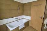 This bathroom features a modern design with a sleek bathtub and a convenient showerhead.
