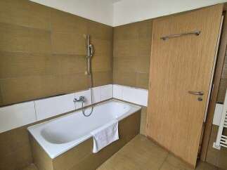 This bathroom features a modern design with a sleek bathtub and a convenient showerhead.