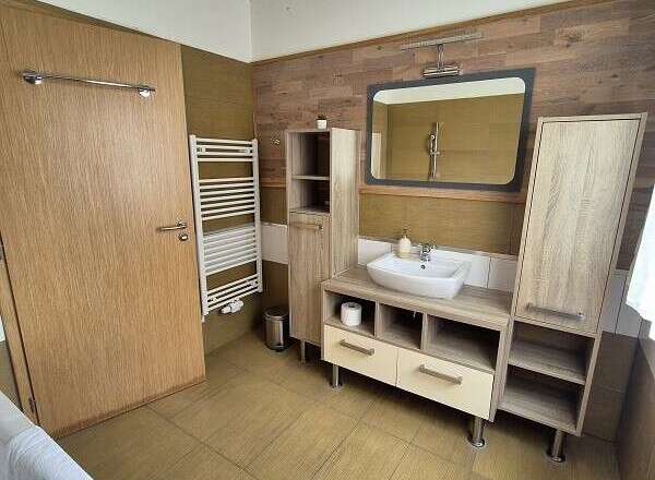 This modern bathroom features a stylish vanity with ample storage and a sleek, rectangular mirror.
