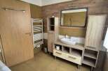 This modern bathroom features a stylish vanity with ample storage and a sleek, rectangular mirror.