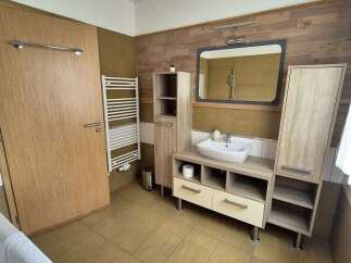 This modern bathroom features a stylish vanity with ample storage and a sleek, rectangular mirror.