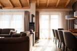 Experience the warmth of this inviting living space, featuring a cozy fireplace and elegant wooden ceiling beams.