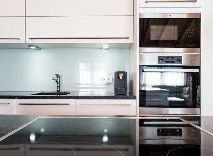 Modern kitchen design featuring sleek white cabinetry and a stylish black countertop.