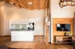 Experience rustic elegance in this stunning property, featuring a modern kitchen with sleek white cabinetry and a stylish island.