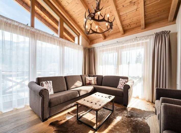 Experience luxury living in this stunning property, featuring a cozy living room with a comfortable sectional sofa and a rustic coffee table.