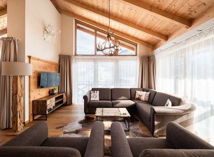 Experience luxury living in this stunning property, featuring a cozy living room with a comfortable sectional sofa and a rustic coffee table.