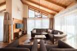 Experience luxury living in this stunning property, featuring a cozy living room with a comfortable sectional sofa and a rustic coffee table.