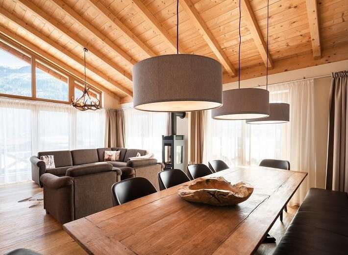 Experience luxury living in this stunning property, featuring a warm and inviting interior with a wooden ceiling and elegant lighting.